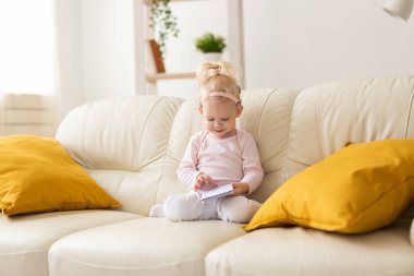 Baby with cochlear implants at home. Deafness and medical technology concept.