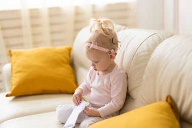 Cochlear implant for baby. Deaf child with hearing aid at home