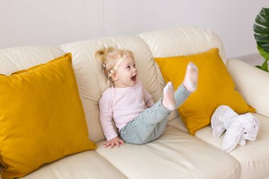 Baby with cochlear implants at home. Deafness and medical technology concept.