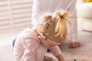 Baby with cochlear implants at home. Deafness and medical technology concept.