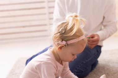 Cochlear implant for baby. Deaf child with hearing aid at home