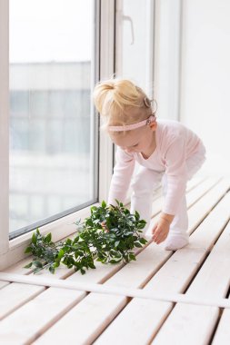 Baby with cochlear implants at home. Deafness and medical technology concept.