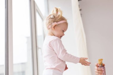 Baby with cochlear implants at home. Deafness and medical technology concept.