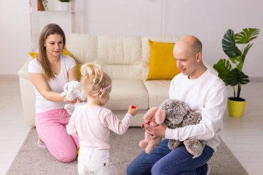 Happy child girl with cochlear implant having fun with her family - hearing aid for deaf and innovative health technology concept