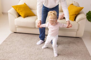 Baby with cochlear implants playing with her father at home. Deafness and medical technology concept