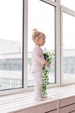 Baby with cochlear implants at home. Deafness and medical technology concept.