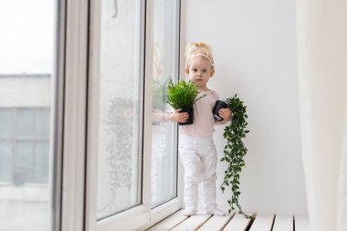 Baby with cochlear implants at home. Deafness and medical technology concept.