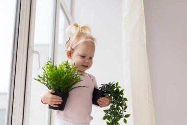 Baby with cochlear implants at home. Deafness and medical technology concept.