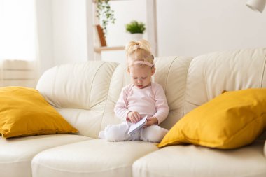 Baby with cochlear implants at home. Deafness and medical technology concept.