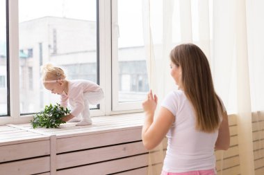 Child girl with cochlear implant with her mother at home. Hear impairment and deaf community concept