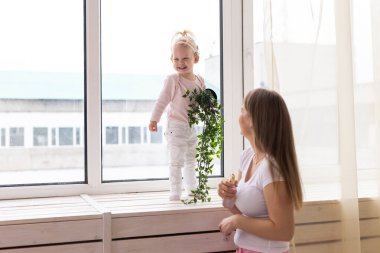 Happy child girl with cochlear implant having fun with her mother - hearing aid for deaf and innovative health technology concept