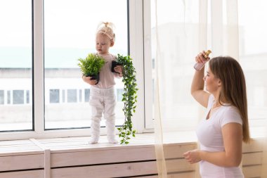 Happy child girl with cochlear implant having fun with her mother - hearing aid for deaf and innovative health technology concept