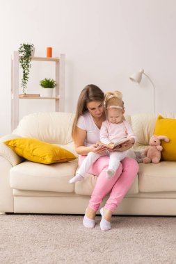 Child girl with cochlear implant with her mother at home. Hear impairment and deaf community concept
