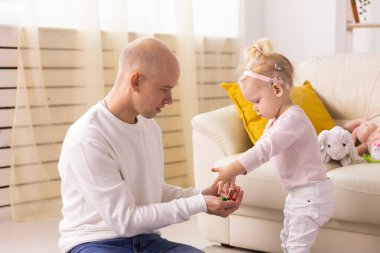 Happy child girl with cochlear implant having fun with her father - hearing aid for deaf and innovative health technology concept