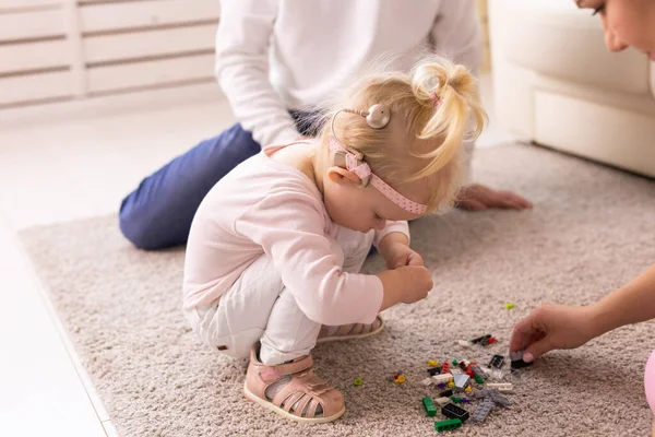 Cochlear implant on the child girl head and playing with mother and father. Hearing aid and deafness and innovative health technology concept