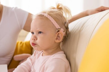 Koklear implantı olan bebek evde eğleniyor. Sağırlık ve tıbbi teknoloji kavramı.