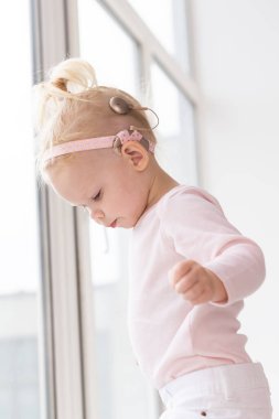 Cochlear implant for baby. Deaf child with hearing aid. Health care and medicine technology and innovations