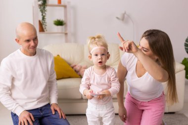 Cochlear implant on the child girl head and playing with mother and father. Hearing aid and deafness and innovative health technology concept