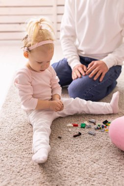 Baby girl with cochlear implants playing with her father at home. Deafness and medical technology and diversity concept