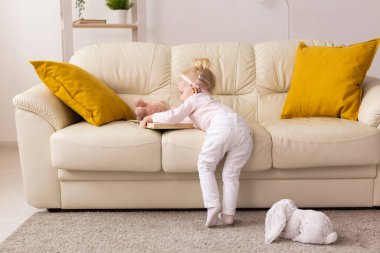 Baby with cochlear implants at home. Deafness and medical technology and diversity concept