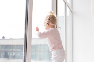 Baby with cochlear implants at home. Deafness and medical technology and diversity concept. Copy space and place for advertising