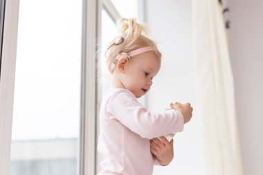 Baby with cochlear implants at home. Deafness and medical technology and diversity concept. Copy space and place for advertising