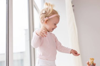 Baby with cochlear implants at home. Deafness and medical technology and diversity concept.