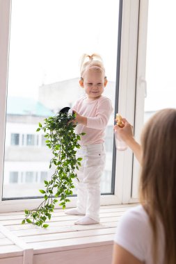 Happy child girl with cochlear implant having fun with her mother - hearing aid for deaf and innovative health technology concept