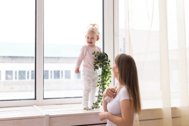 Baby with cochlear implants at home. Deafness and medical technology concept.