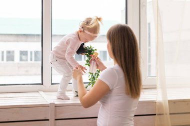 Child girl with cochlear implant with her mother at home. Hear impairment and deaf community concept