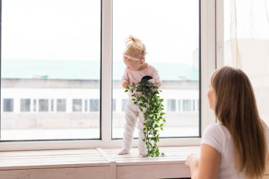 Baby with cochlear implants at home. Deafness and medical technology concept.
