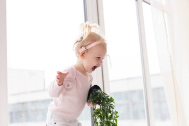 Baby with cochlear implants at home. Deafness and medical technology concept.