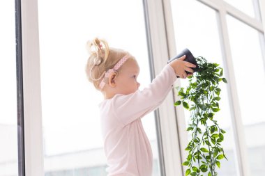 Baby with cochlear implants at home. Deafness and medical technology concept.