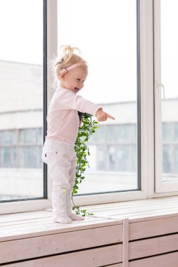 Baby with cochlear implants at home. Deafness and medical technology concept.