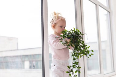 Baby with cochlear implants at home. Deafness and medical technology concept.