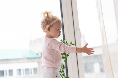 Baby with cochlear implants at home. Deafness and medical technology concept.