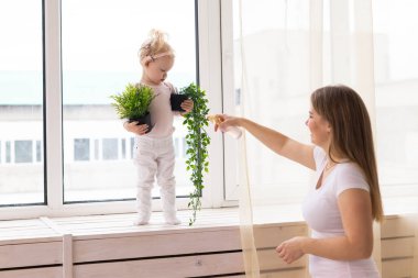 Happy child girl with cochlear implant having fun with her mother - hearing aid for deaf and innovative health technology concept
