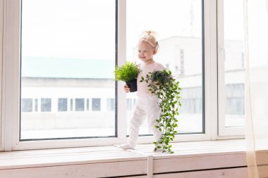 Baby with cochlear implants at home. Deafness and medical technology concept.