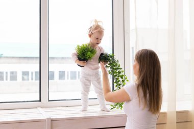 Happy child girl with cochlear implant having fun with her mother - hearing aid for deaf and innovative health technology concept