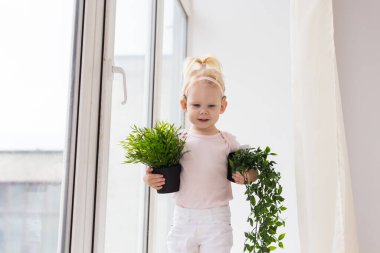 Baby with cochlear implants at home. Deafness and medical technology concept.
