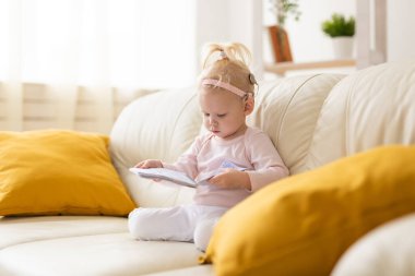 Baby with cochlear implants at home. Deafness and medical technology concept.