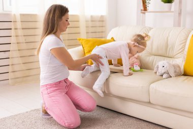 Happy child girl with cochlear implant having fun with her mother - hearing aid for deaf and innovative health technology and diversity concept
