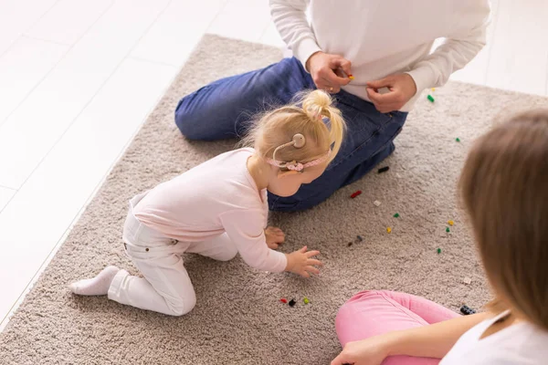 Happy child girl with cochlear implant having fun with her father - hearing aid for deaf and innovative health technology and diversity concept