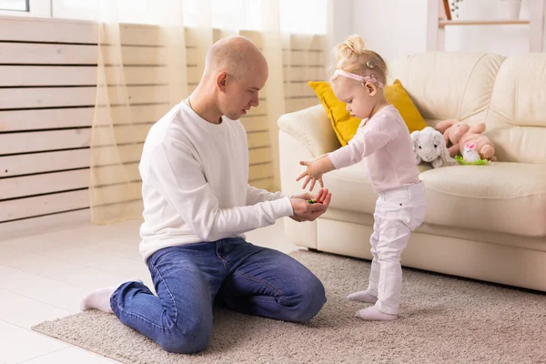 Happy child girl with cochlear implant having fun with her father - hearing aid for deaf and innovative health technology and diversity concept
