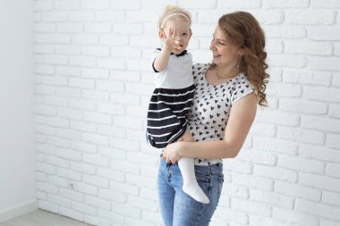 Baby with cochlear implant hearing aid having fun with her mother - deafness and diversity concept. Copy space and place for advertising