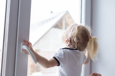 Baby with cochlear implant hearing aid having fun with her mother - deafness and diversity concept. Copy space and place for advertising