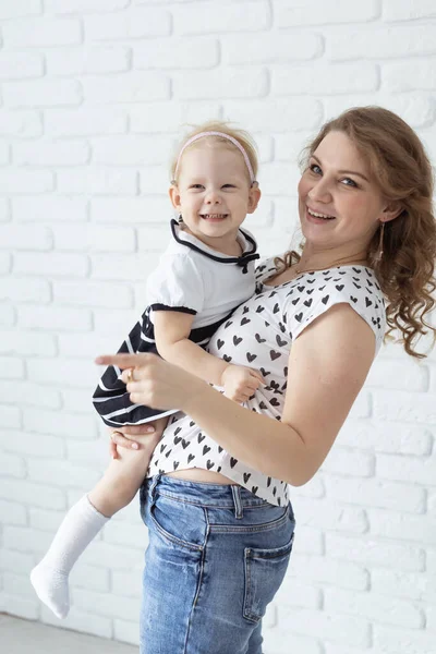 Baby with cochlear implant hearing aid having fun with her mother - deafness and diversity concept.