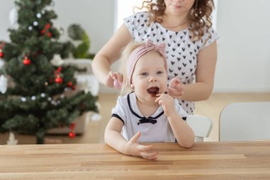 Mother fixing her daughters cochlear implant hearing aid - deafness and diversity concept. Innovative technologies in treatment deafness