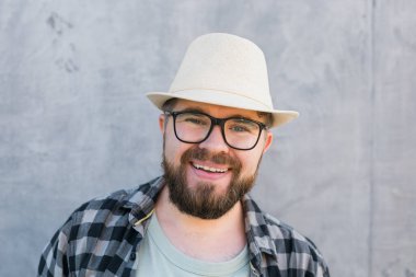 guy tourist looking happy wearing straw hat for travelling, standing against concrete wall background with copy space