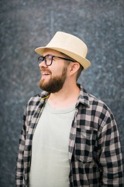 guy tourist looking happy wearing straw hat for travelling, standing against concrete wall background with copy space